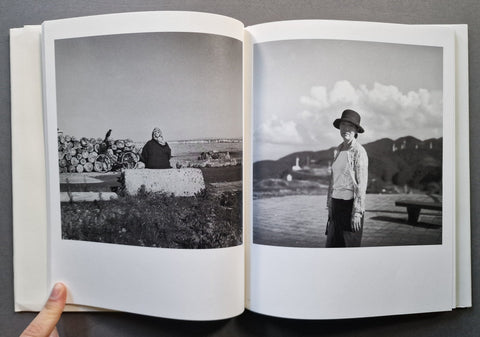 An open book spread with two black and white photographs - on the left a woman looking at the sea, on the right a woman looking straight in the camera
