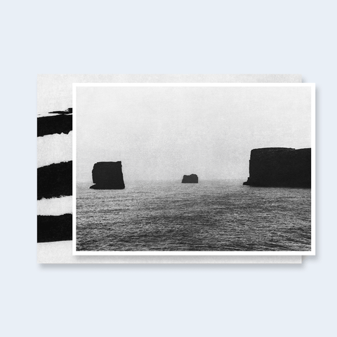 The deluxe edition of Unseen by Jungjin Lee featuring the cover in gray and black and the limited edition signed print of a seascape with rocks in black and white