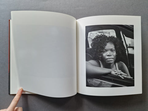 An open book, showing a blank left page and a black-and-white portrait print on the right page. 