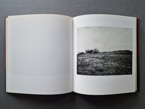 An open book, showing a black-and-white landscape photograph printed on the right page.