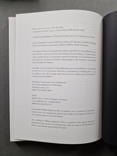 An open book showing printed text on white pages, photographed from above against a dark gray background.