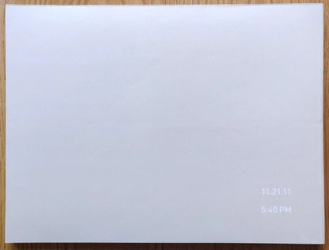 The photography book cover of 11.21.11 5:40PM by Richard Misrach. Hardback in white with white title in the corner.