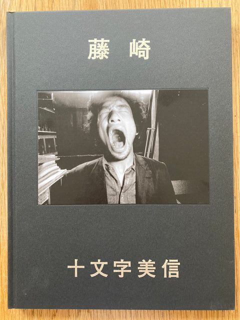 The photography book cover of Fujisaki by Bishin Jumonji. Hardback in black with a man screaming on the cover. Signed.