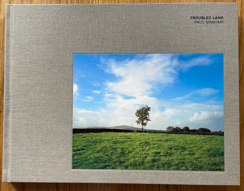 The photobook cover of Troubled Land signed by Paul Graham. In hardcover grey. Signed.