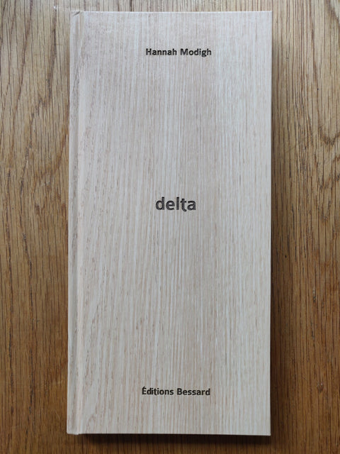 The photography book cover of Delta by Hannah Modigh. Hardback with a wooden pattern as cover.