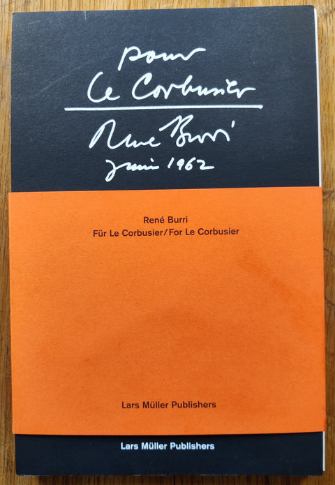 The photobook cover of Pour Le Corbusier by René Burri. In softcover black with an orange bellyband.