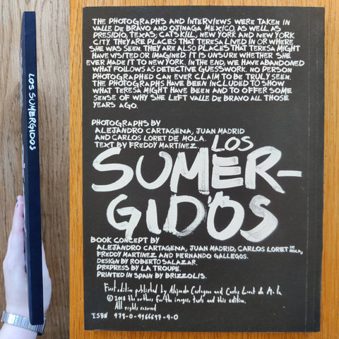 The phootgraphy book cover of Los Sumergidos by Alejandro Cartagena, Juan Madrid and Carlos Loret De Mola. In softcover black.
