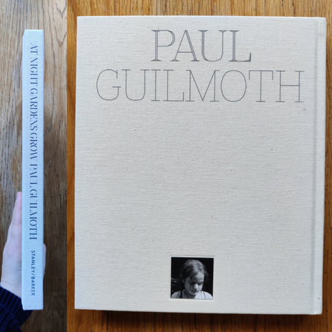The photography book cover of At Night Gardens Grow by Paul Guilmoth. In hardcover white.