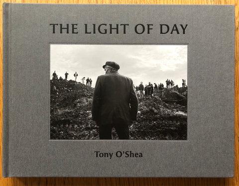 The photography book cover of The Light of Day by Tony O'Shea. Hardback in light grey.