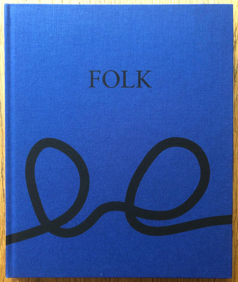 The photography book cover of Folk by Aaron Schuman. Hardback in blue. Signed.