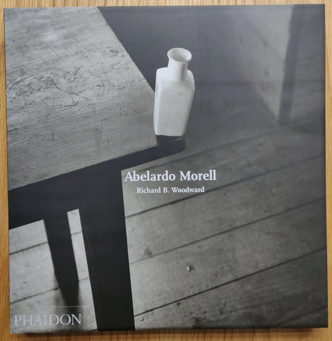 The photography book cover of Abelardo Morell by Abelardo Morell. Hardback with B&W cover photo of a vase on the very corner of a table.