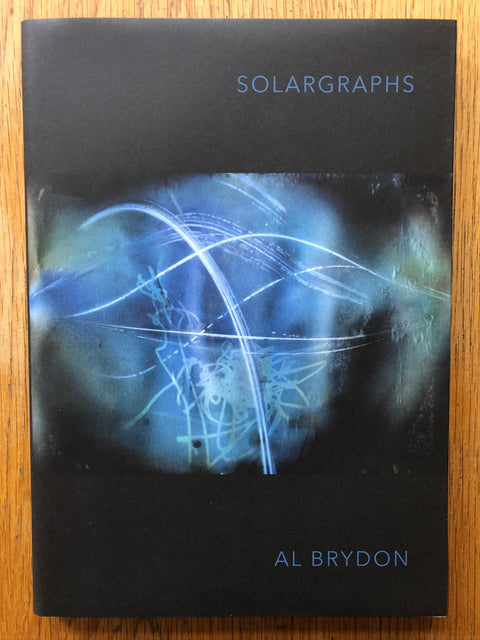 The photography book cover of Solargraphs by Al Brydon. Hardback in black with blue funky design on the cover.