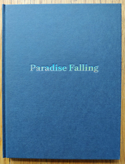 The photography book cover of Paradise Falling by Alana Celii. Hardback in blue.