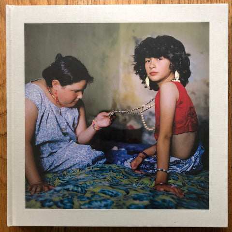 The photography book cover of The Adventure of Guille and Belinda and the enigmatic meaning of their dreams by Alessandra Sanguinetti. Hardback with image of two young girls playing with jewellery.