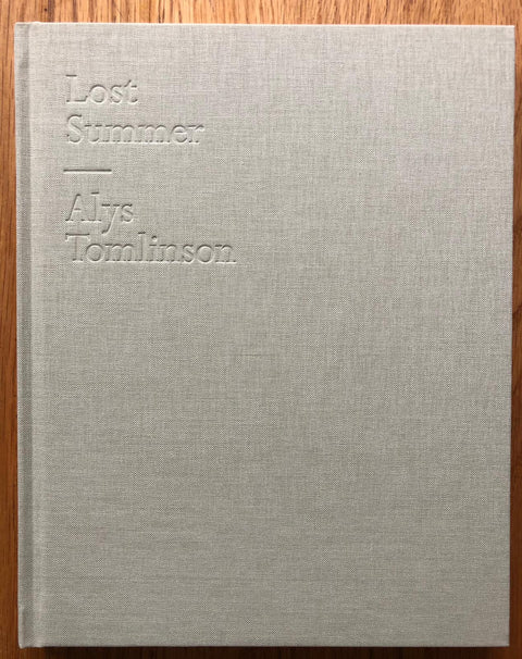 The photography book cover of Lost Summer by Alys Tomlinson. Hardback in light grey. Signed.