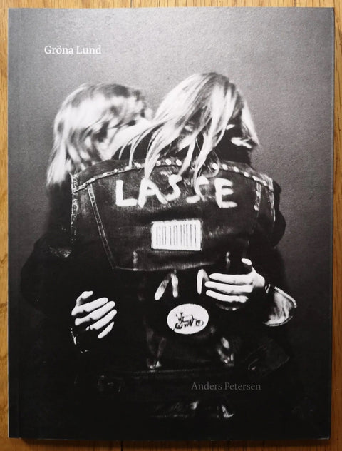 The photography book cover of Grona Lund by Anders Petersen. Paperback in B&W, cover image of two people hugging/kissing each other.