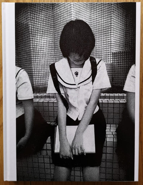 The photography book cover of Okinawa by Anders Petersen. Hardback in B&W, image of school child looking down. Signed.