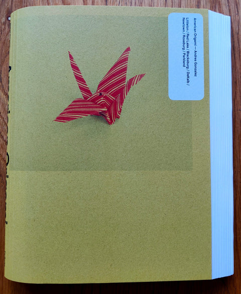 The photography book cover of American Origami by Andres Gonzalez. Paperback with a red and yellow crane on the cover.