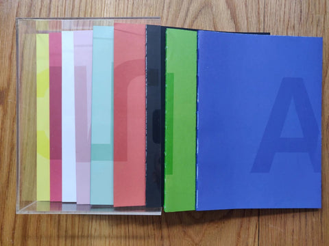 The photography book covers of Automagic by Anouk Kruithof. Different coloured paperback books in a perspex case.