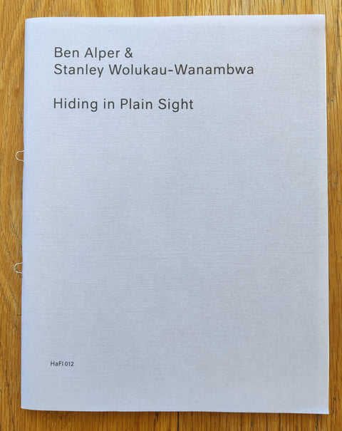The photobook cover of Hiding in Plain Sight by Ben Alper and Stanley Wolukau-Wanambwa. In softcover light purple.