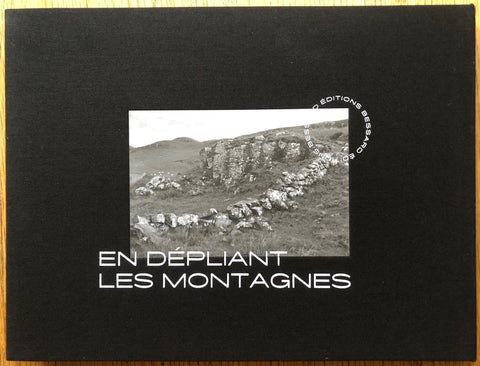 The photography book cover of En Depliant les Montagnes by Bernard Plossu. Hardback in black with B&W image of a hillside. Signed.