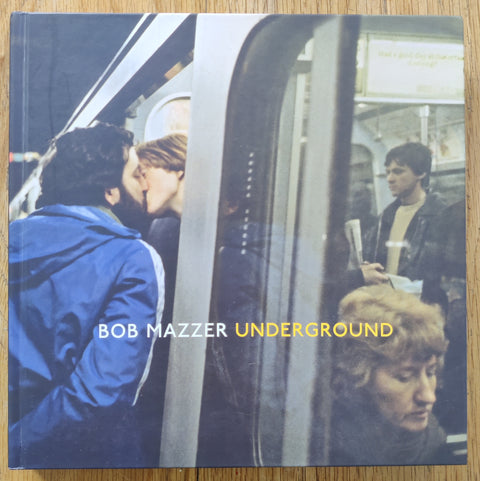 The photobook cover of Underground by Bob Mazzer . In hardcover with a photo of a couple kissing on the tube.
