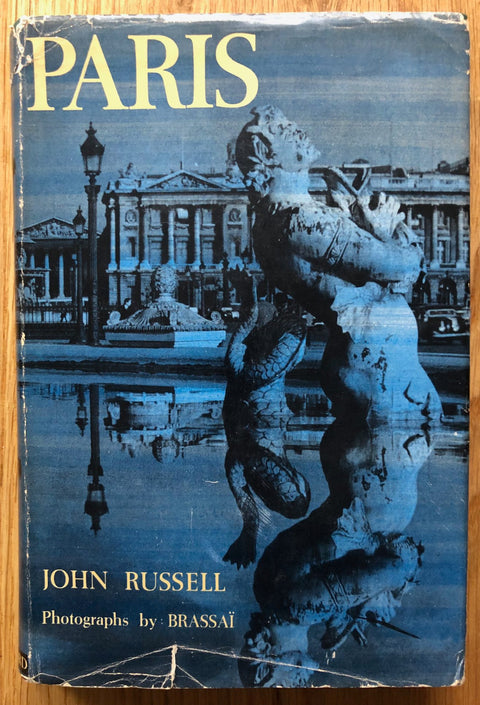 The photography book cover of Paris by Brassai and John Russell. Hardback with blue tinted image of statue.
