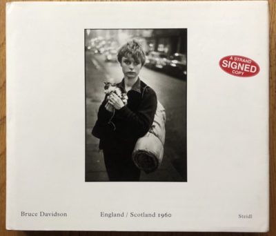 The photography book cover of England / Scotland 1960 by Bruce Davidson. Hardback n white with B&W image of someone holding a cat. Signed.