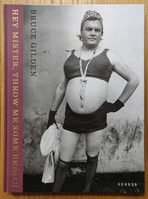 The photography book cover of Hey Mister, Throw Me Some Beads by Bruce Gilden. Hardback in black and white with a man wearing a cropped top and skirt on the cover.