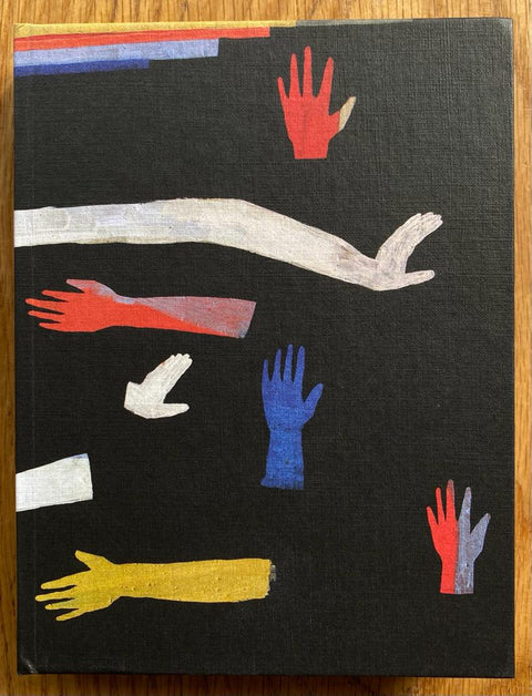 The photography book cover of Jeux de Mains by Cecile Poimboeuf-Koizumi and Stephen Ellcock. Hardback in black with paintings of hands and arms in different directions. Primary colours. Signed.
