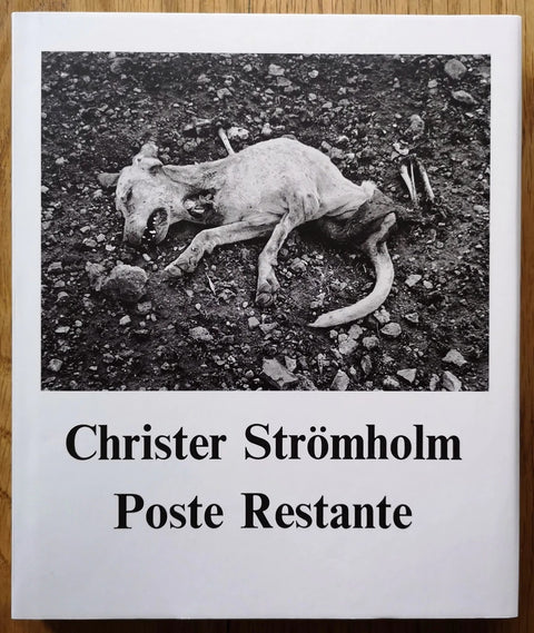The photography book cover of Poste Restante by Christer Stromholm. Hardback with B&W image of a deceased dog.