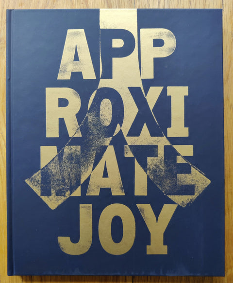 The photobook cover of Approximate Joy by Christopher Anderson. Hardback in navy with big gold title. Signed.