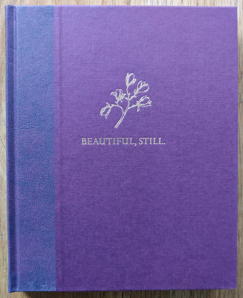 The photobook cover of Beautiful, Still. by Colby Deal. In hardcover purple with a blue spine. Signed.