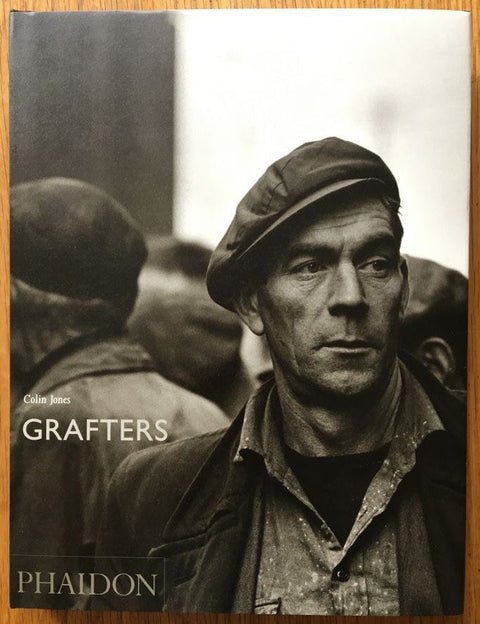 The photography book cover of Grafters by Colin Jones. Hardback with a black and white photograph of a man on the front.