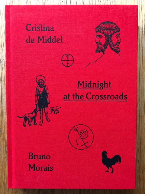 The photography book cover of Midnight at the Crossroads by Cristina de Middel and Bruno Morais. Hardback in red. Signed.