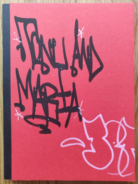 The photography book cover of SPBH Book Club Vol III by Cristina De Middel. Hardback in red with black spine and graffiti on the cover.