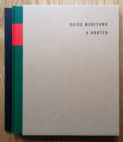 The photography book cover of A Hunter by Daido Moriyama. Hardback slipcased set with a beige over. Signed.