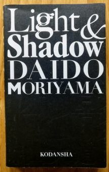 The photography book cover of Light and Shadow by Daido Moriyama. Softcover black cover with large white title.