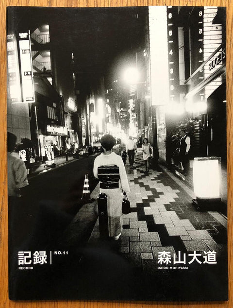 The photography book cover of Record NO.11 by Daido Moriyama. Paperback in B&W with image of a street at night. Signed.