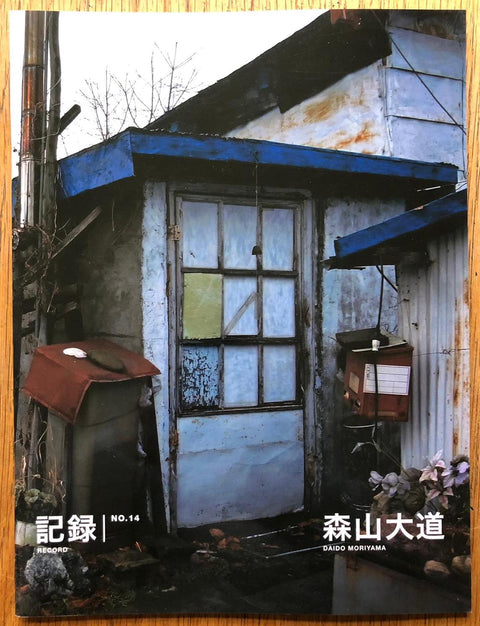 The photography book cover of Record NO.14 by Daido Moriyama. Paperback with image of a run down house on the cover. Signed.