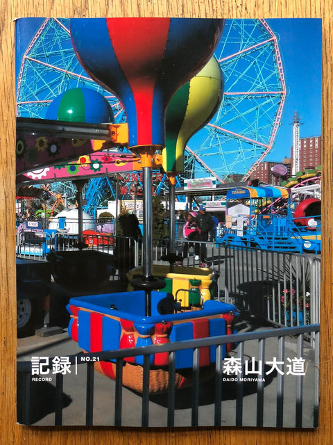 The photography book cover of Record NO.21 by Daido Moriyama. Paperback with image of a fairground on the cover. Signed.