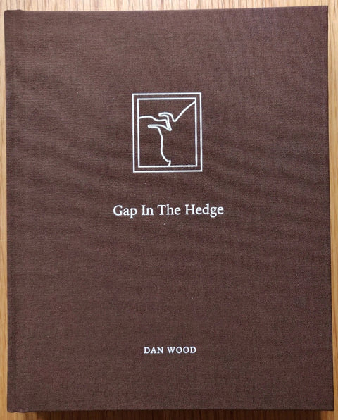 The photography book cover of Gap in the Hedge by Dan Wood. Hardback in brown.