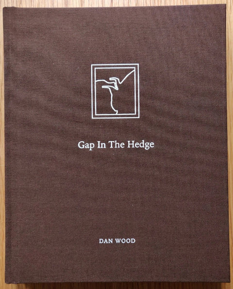 The photography book cover of Gap in the Hedge by Dan Wood. Hardback in brown.