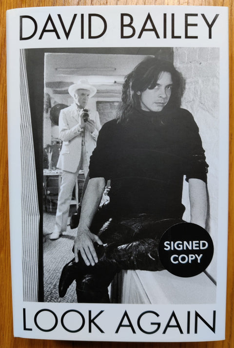 The photography book cover of Look Again: The Autobiography by David Bailey. Hardback with B&W image of a man looking into the camera. Signed.