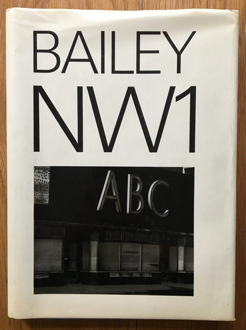 The photography book cover of NW1 by David Bailey. Hardback white cover with black and white image "ABC".