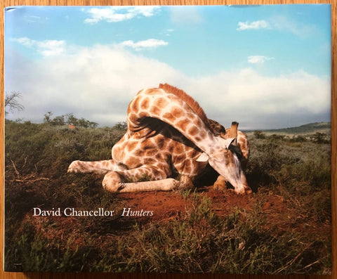 The photobook cover of Hunters by David Chancellor. Hardback with cover image of a seated Giraffe.