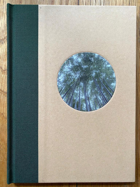 The photography book cover of A Walk through a bamboo grove, Hokoku-ji, Kamakura, Kanagawa, Japan by David H. Gibson. Hardback in beige with dark green spine and image of trees in a circle.