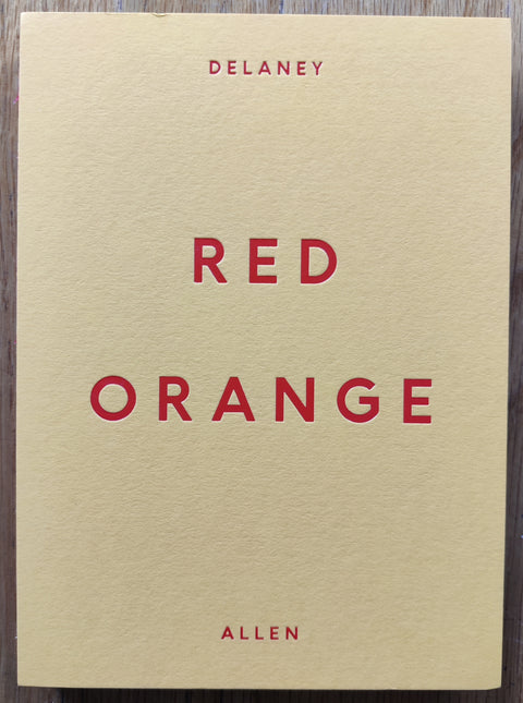 The photobook cover of Red Orange by Delaney Allen. In hardcover yellow and red. With a signed print.