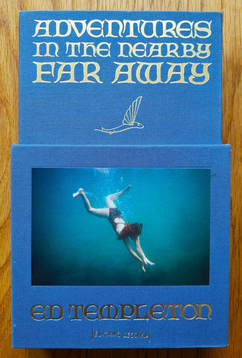 The photobook cover of Adventures in the Nearby Far Away by Ed Templeton. Hardback in blue, slipcase with image of someone swimming.