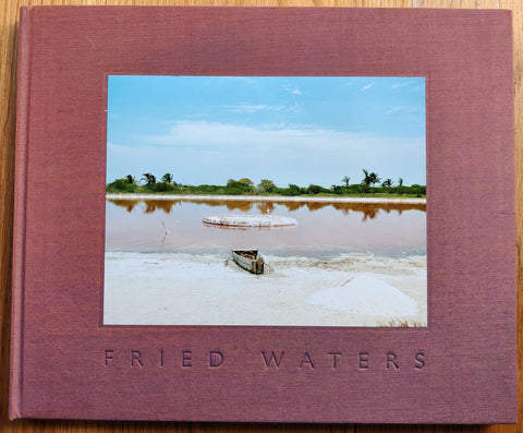 The photography book cover of Fried Waters by Eduardo del Valle and Mirta Gomez. Hardback in red/purple. Signed.